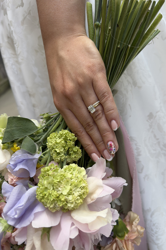 Brides hand with her engagement and wedding ring on, holding a pastel bouquet. Documented by Scottish wedding content creator, Content by Gail